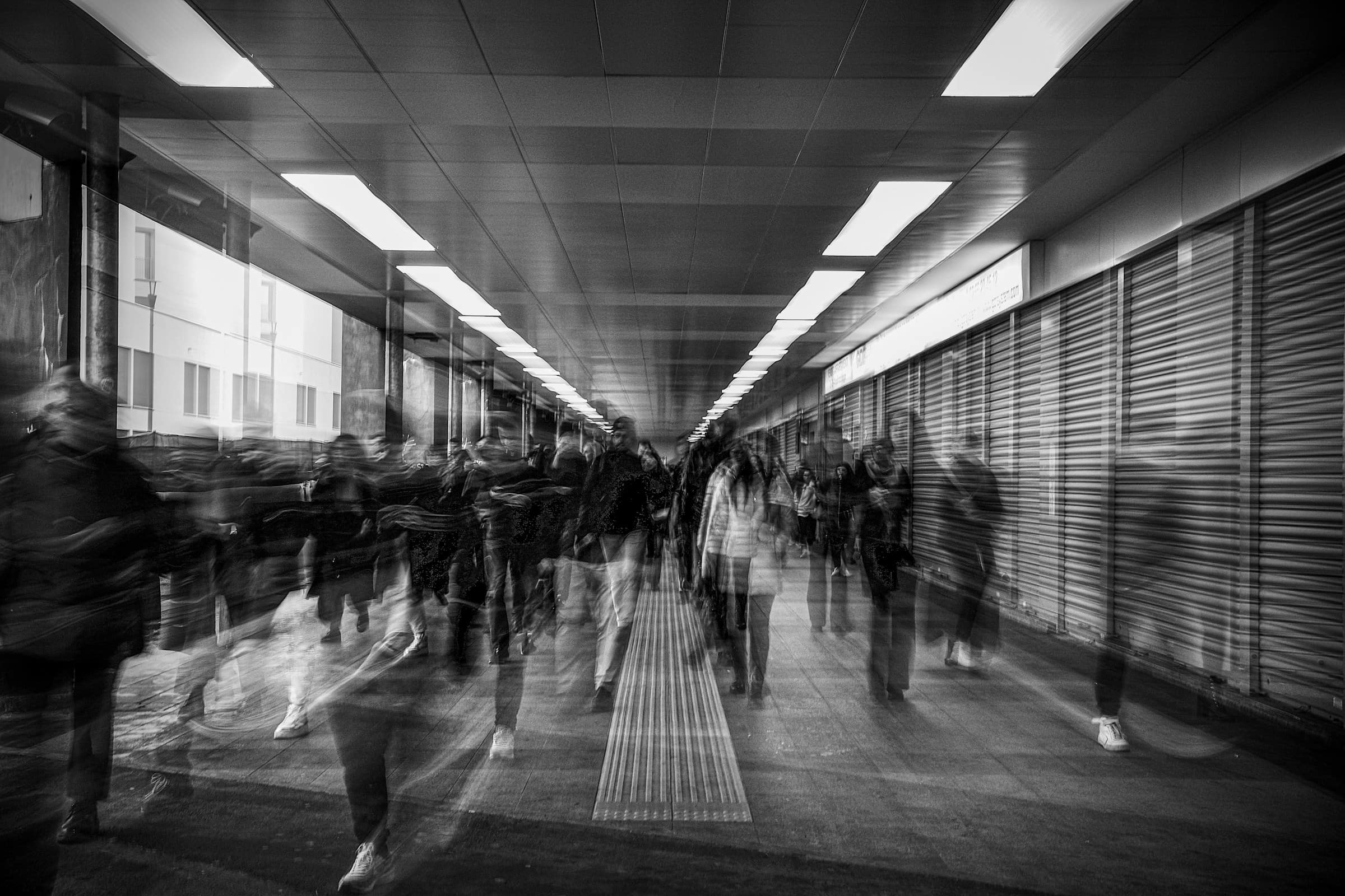 A long exposure of people moving through a busy corridor